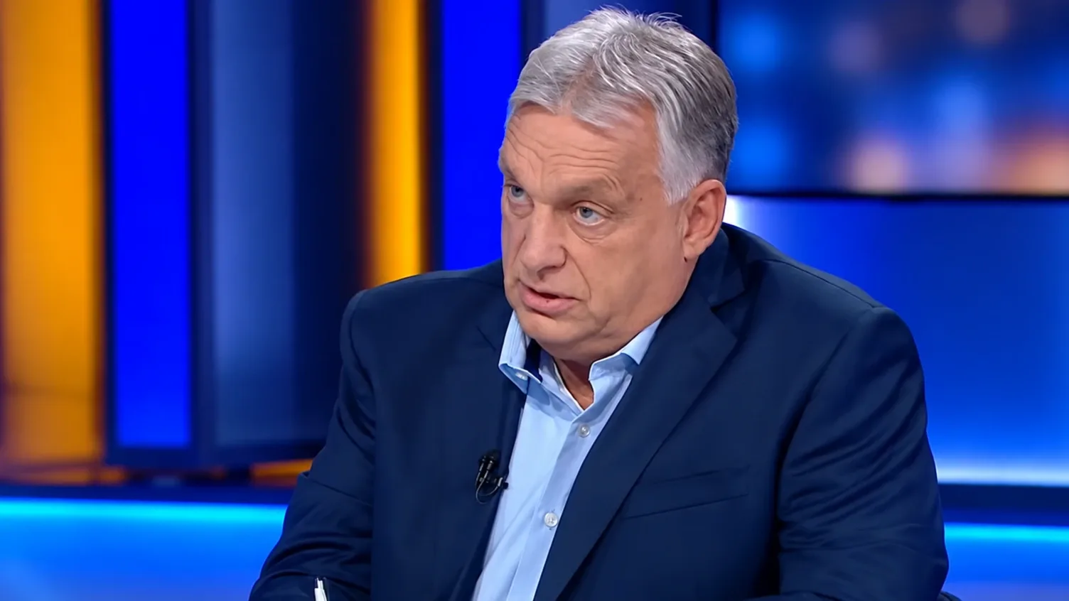 Orbán Viktor sötét zakóban televíziós stúdióban, kék háttér előtt.