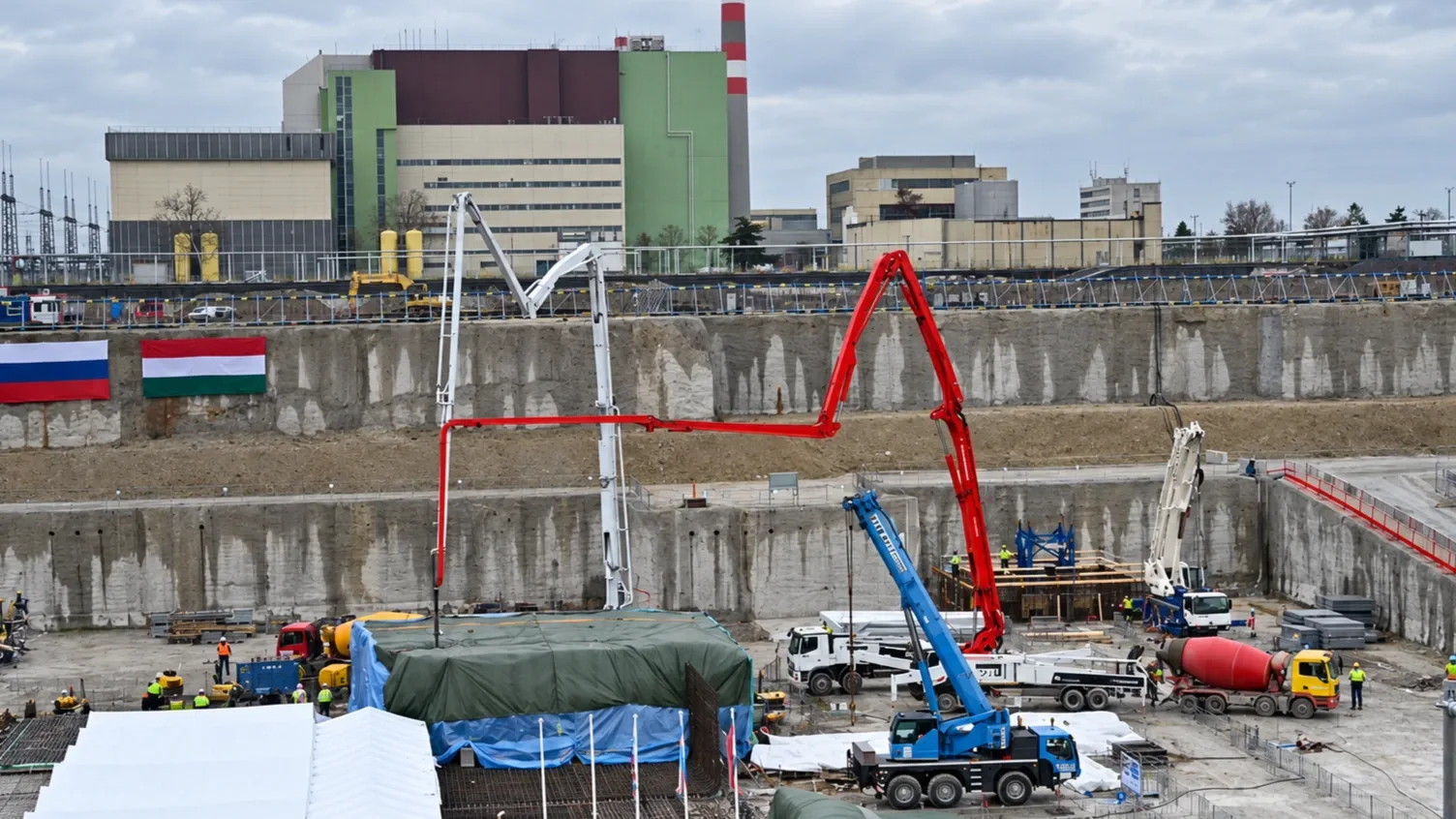 A Paks II. építési területe darukkal, betonozási munkákkal, valamint magyar és orosz zászlóval az atomerőmű közelében.