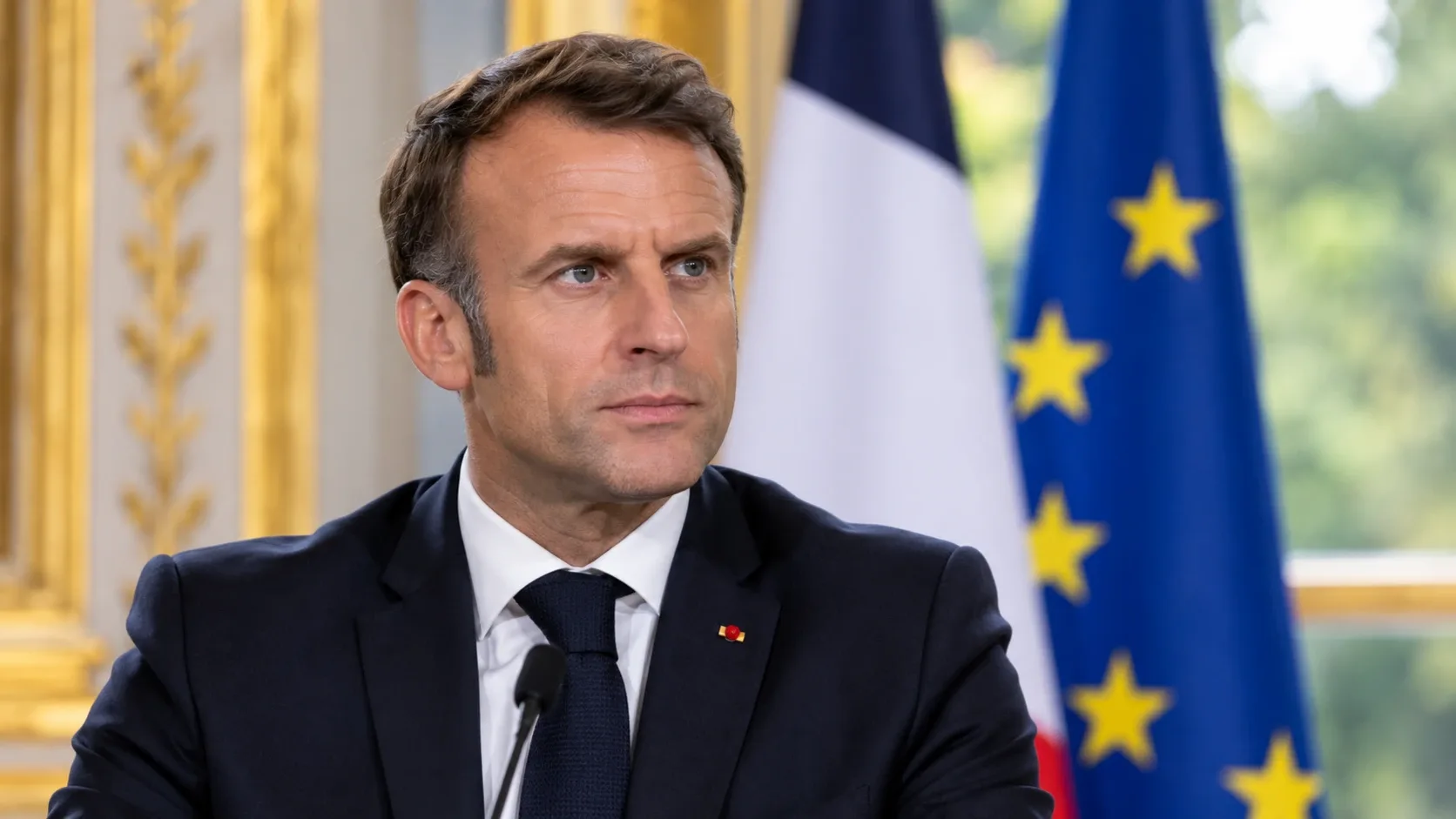 Emmanuel Macront ábrázoló illusztráció francia és európai uniós zászló előtt.