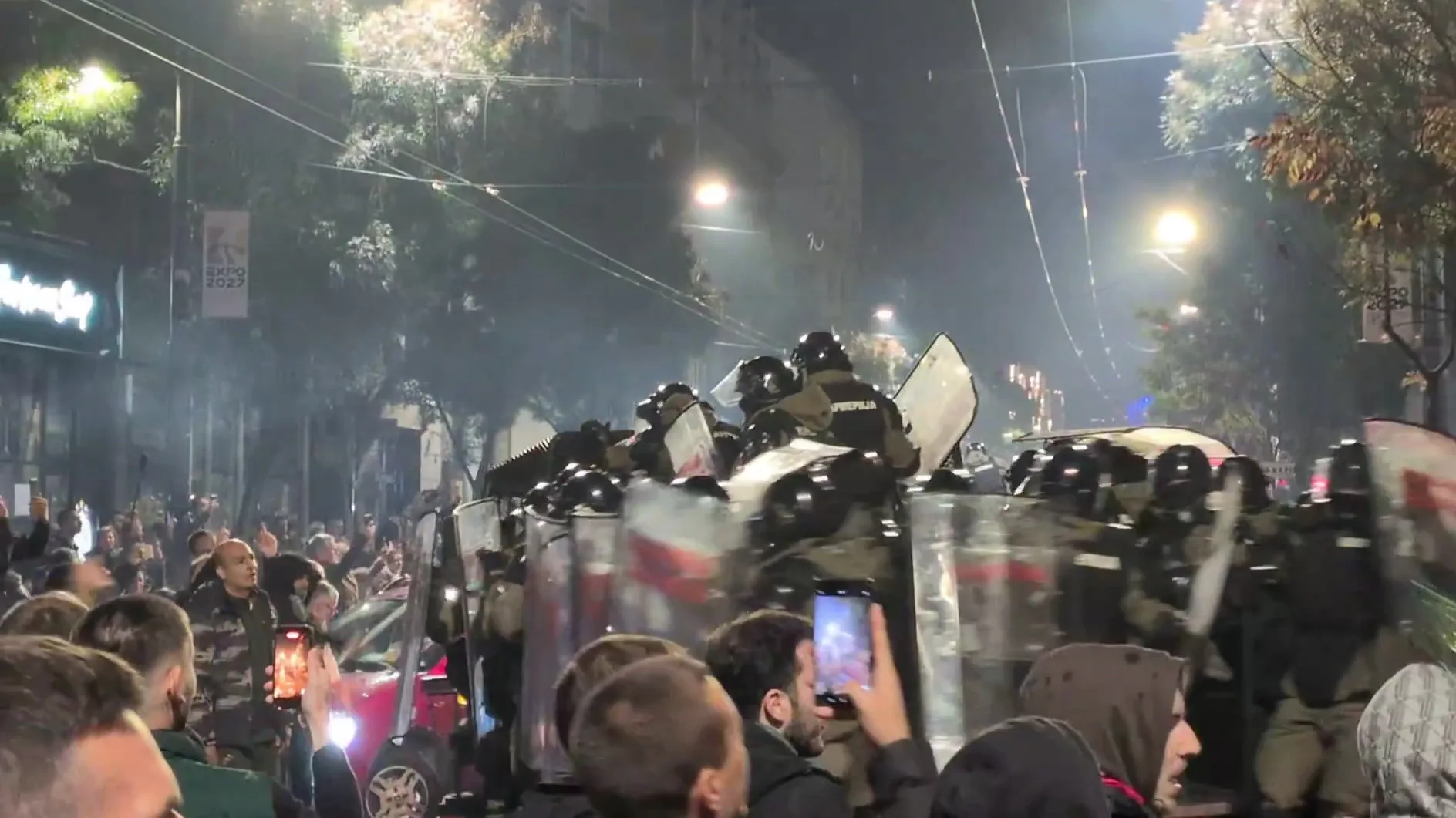 pajzsos rohamrendőrök és a telefonozó tömeg