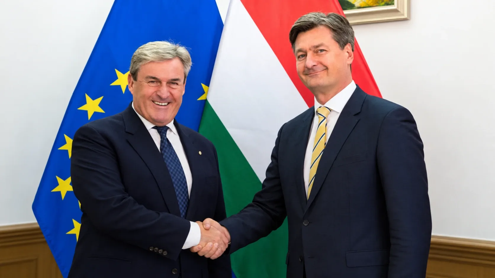 Kapitány István és Herczku György kezet fog, háttérben magyar és uniós zászlóval.