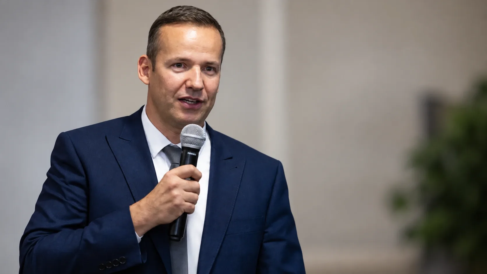 Toroczkai László mikrofonnal a kezében, beszéd közben.