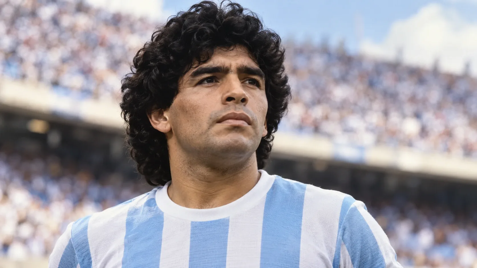 Diego Maradona portréja világoskék-fehér argentin mezben, elmosódott stadionháttér előtt.