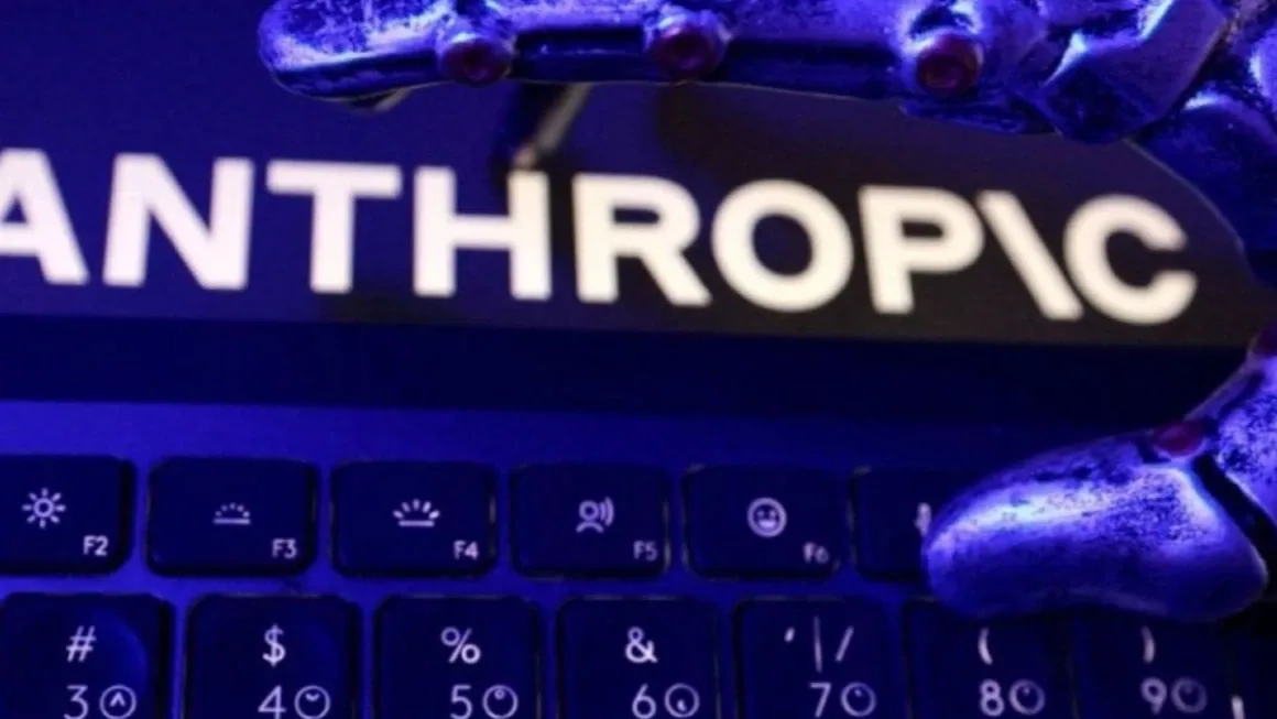 Robotkéz egy laptop billentyűzete fölött, a háttérben az Anthropic feliratával.