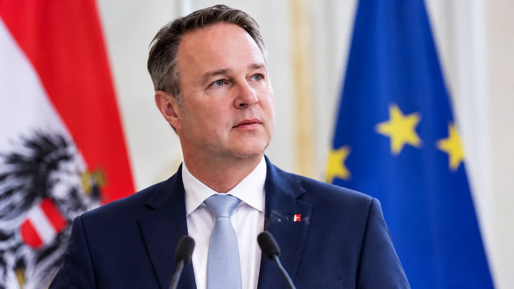 Andreas Bablert ábrázoló AI-generált illusztráció osztrák és európai uniós zászló előtt.